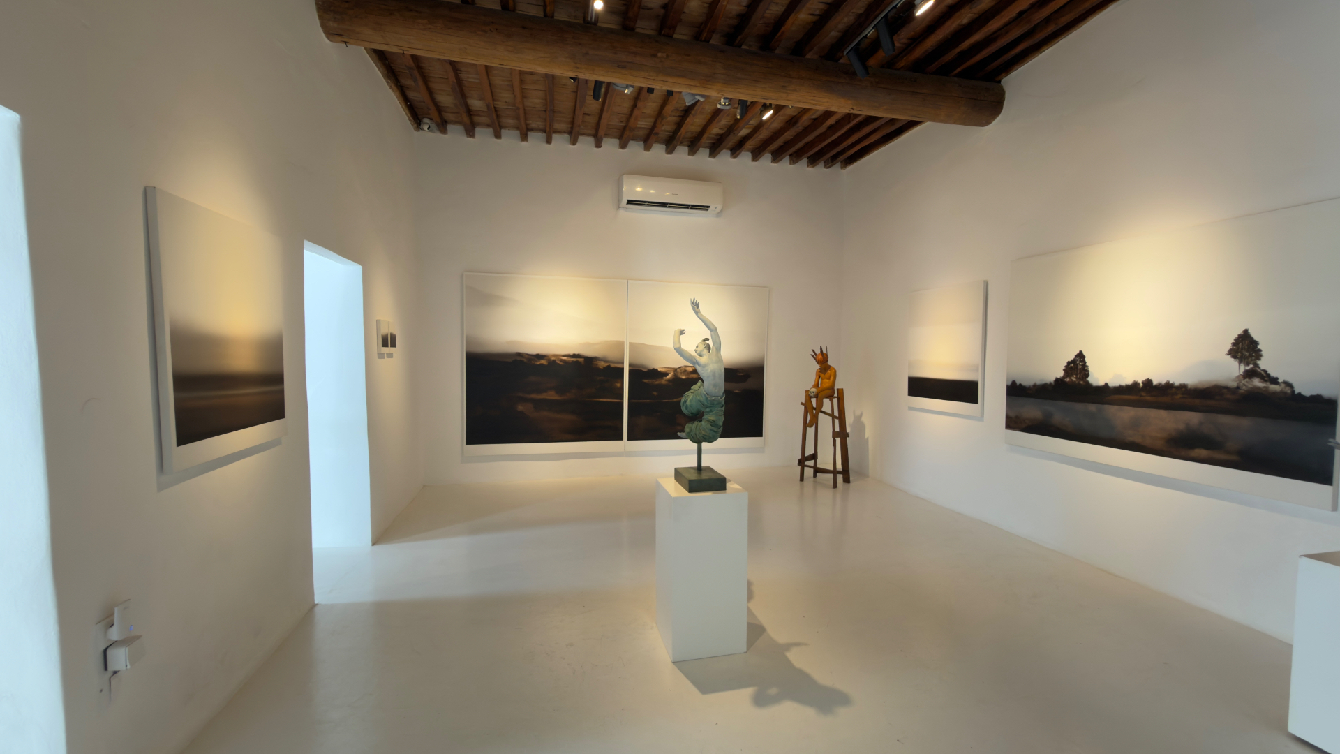 Minima Gallery exhibition room with landscape paintings and sculpture